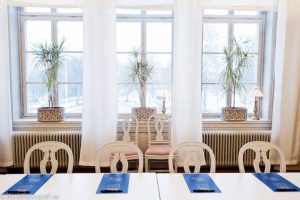 Konferenslokal på slottet med fyra stolar i förgrund, blå anteckningsblock