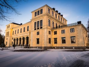 Slottet med snö utanför sam granar på terrassen