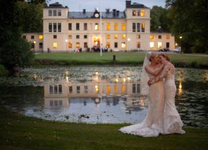 Brudpar står vid dammen med slottet i bakgrunden