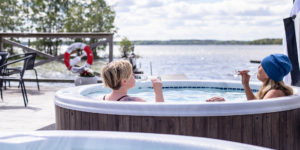 Två kvinnor dricker bubbel i bubbelbad