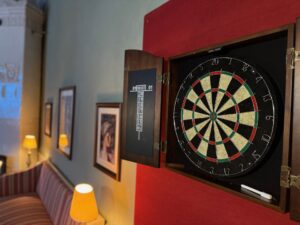 Darttavla som sitter på en röd bakgrund. 