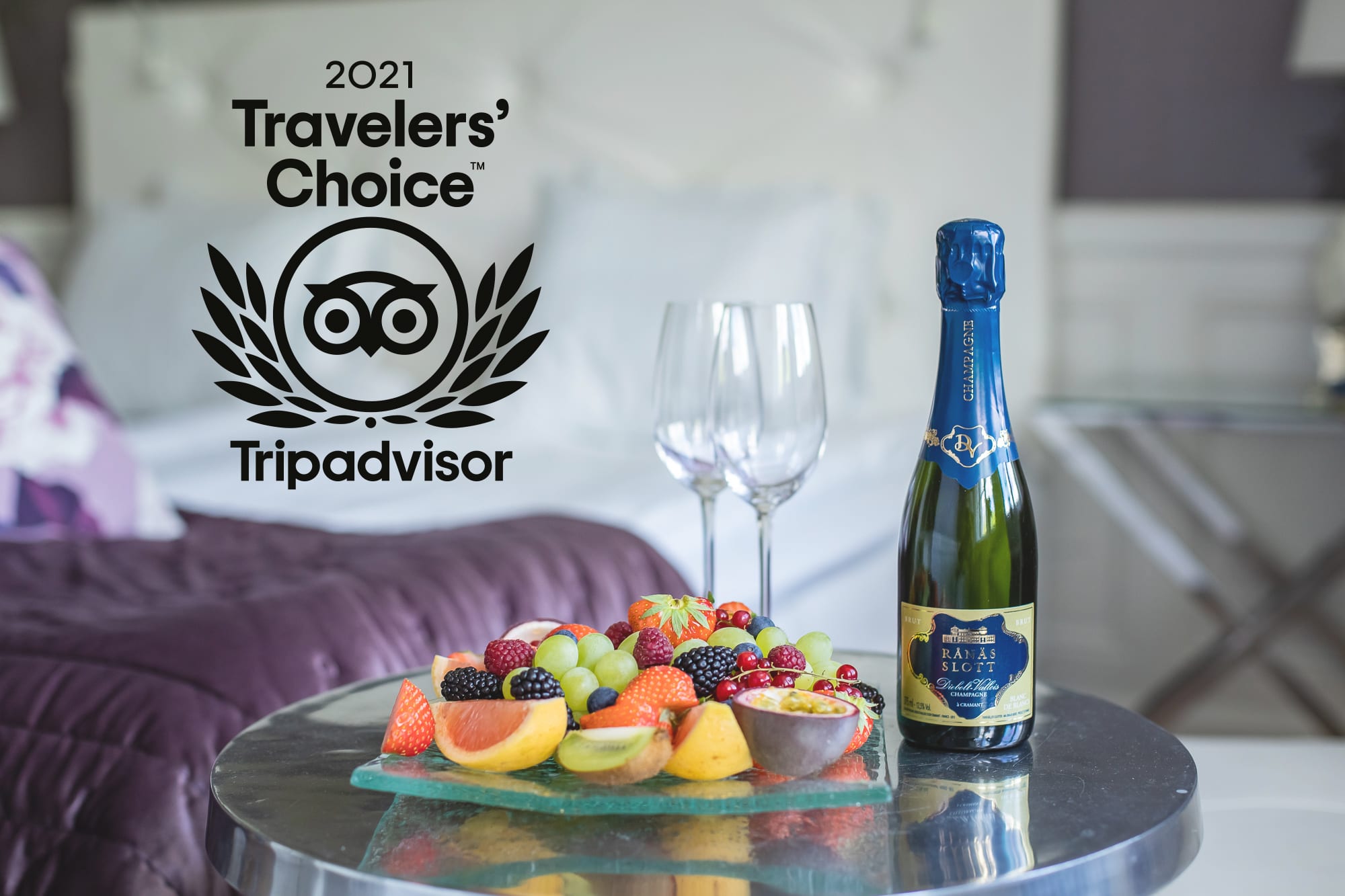 En flaska champagne och frukt samt logga Travelers choice