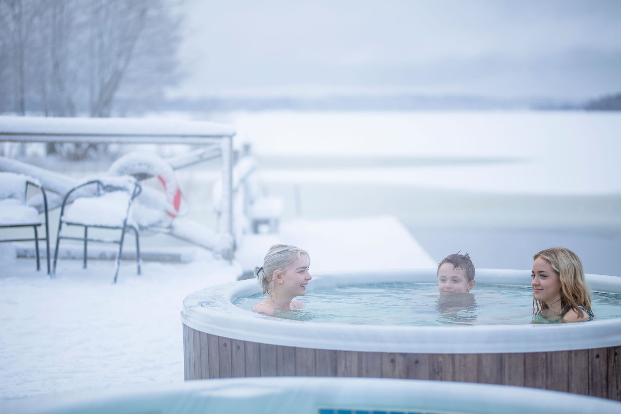 Barn som badar bubbelbad på bryggan