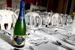 en champagneflaska från Diebolt Vallois står på dukat bord med vita dukar.