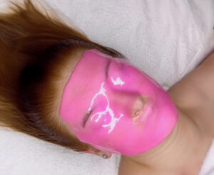 Kvinna med som har en rosa ansiktsmask
